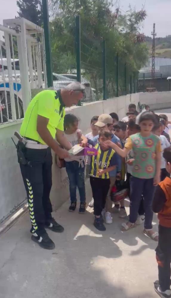 Hatay’da polis ekiplerinin okul önünde sıra bekleyen öğrencilere çikolata dağıtması,
