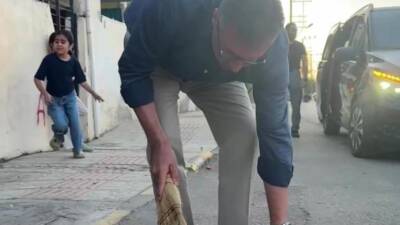 Hatay’ın İskenderun ilçesinde evinin bulunduğu sokağı süpürerek temizleyen kadını gören