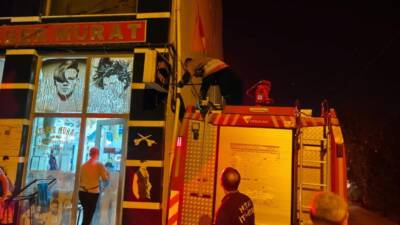 Hatay’ın İskenderun ilçesinde bir işletmenin reklam panosuna sıkışan kedi, itfaiye