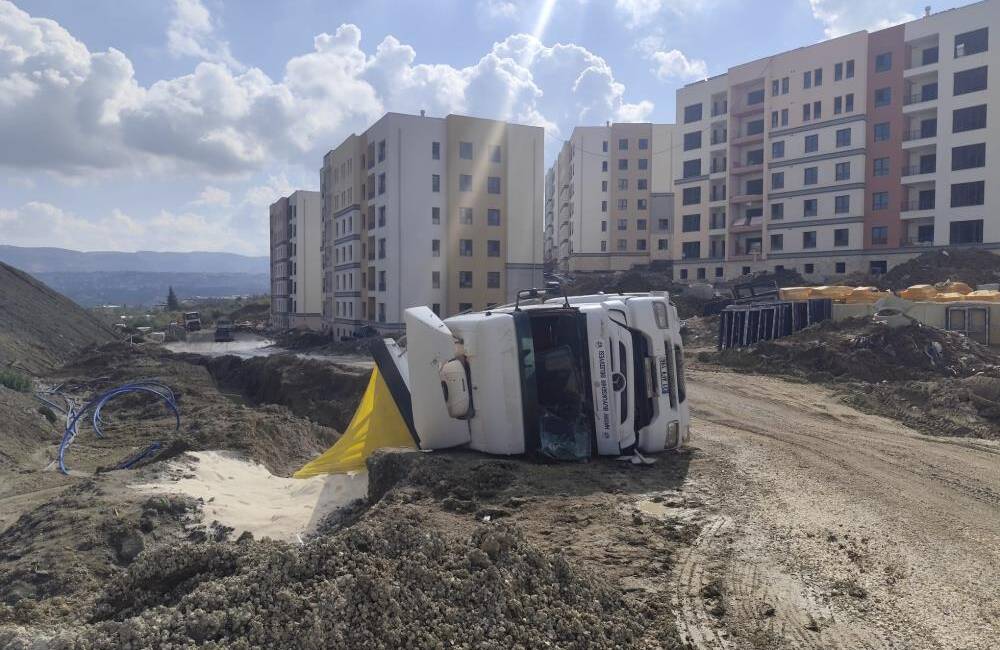 Hatay’ın Defne ilçesinde kum yüklü bir kamyonun devrilmesi sonucu sürücü
