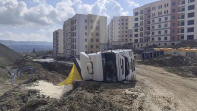 Hatay’ın Defne ilçesinde kum yüklü bir kamyonun devrilmesi sonucu sürücü